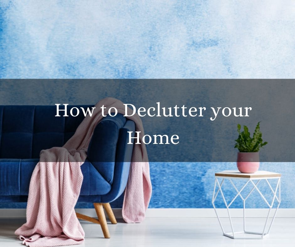 blue couch ina blue room with a pink blanket and a coffee table with a plant