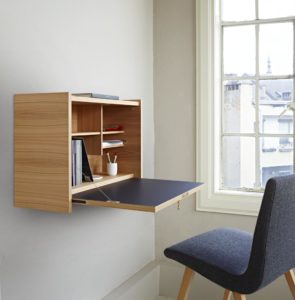 small fold down desk in city apartment next to window