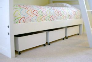 rolling boxes stored underneath a child's bed