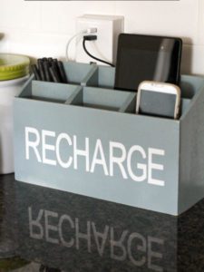 old magazine rack reused as a charging station for phones and laptops
