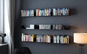 floating shelves on a black wall stored in a teenager's bedroom