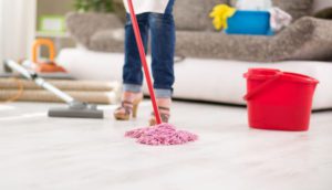 woman mopping a dirty floor in her house 